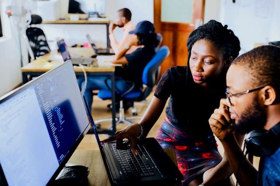 An instructor mentoring a student through coding at Tech Hub